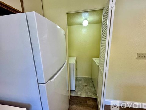 A white refrigerator is in a kitchen with a white door.