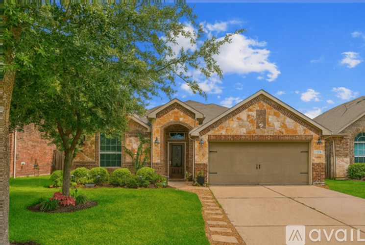 A house with a driveway and a tree in front.