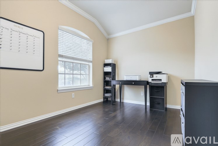 A room with a desk, a printer, and a bookshelf.