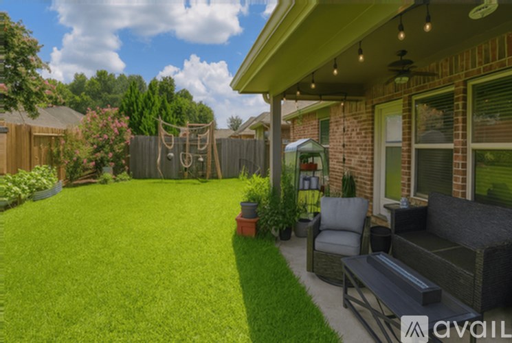 A backyard with a lawn, a patio, and a swing set.