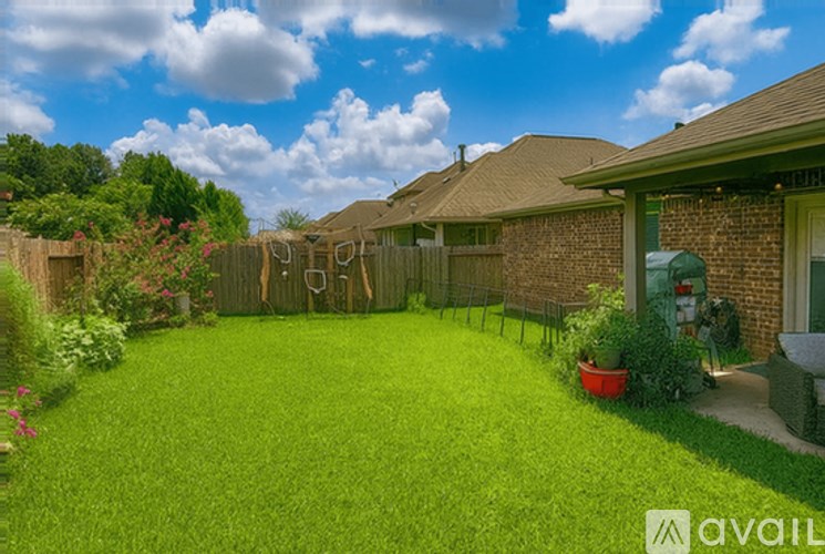 A backyard with a lawn and a fence.