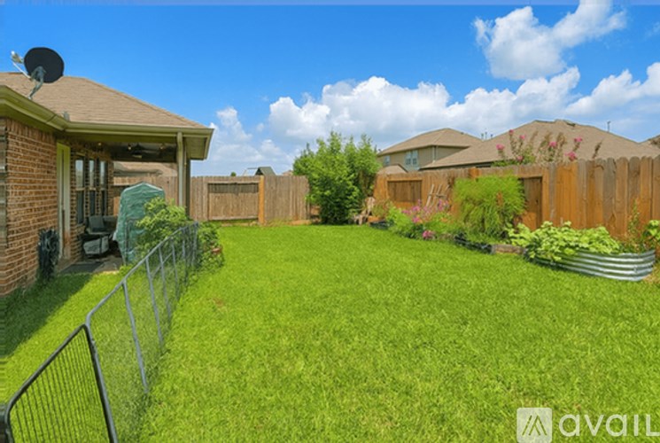 A backyard with a fence and a house.