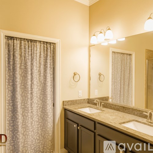 A bathroom with a sink, mirror and shower curtain.