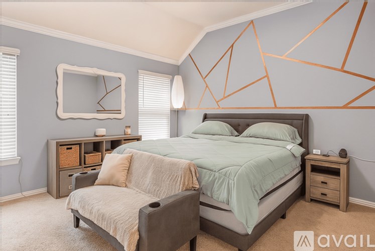 A bedroom with a bed, nightstand, and chair.