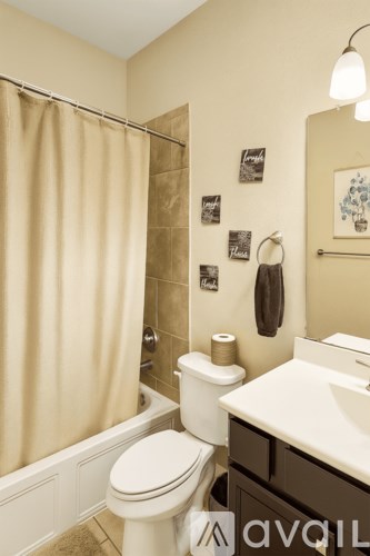 A bathroom with a toilet, sink, and shower.