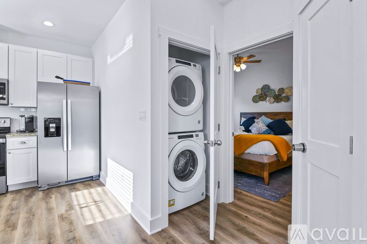 A small bedroom with a washer and dryer built into the wall.