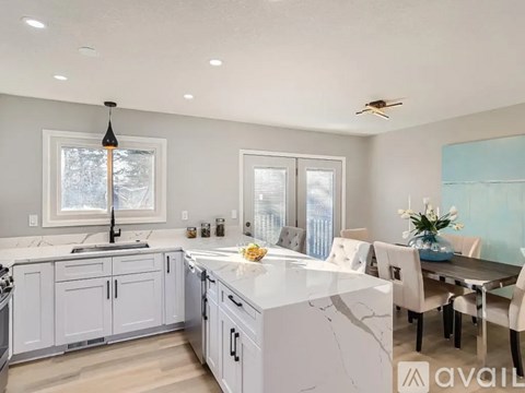 A modern kitchen with a dining table set for two.