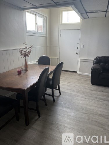 A dining room with a wooden table and chairs.