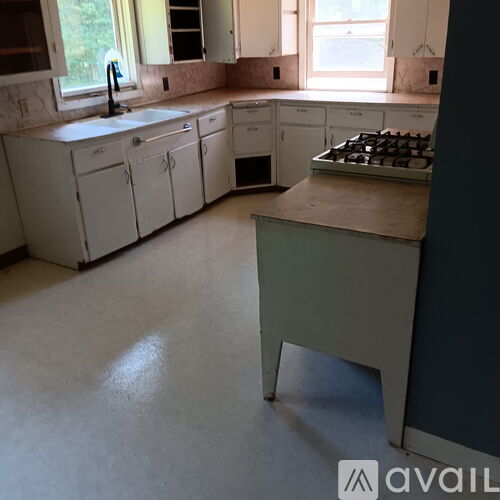 A kitchen with white cabinets and a window.