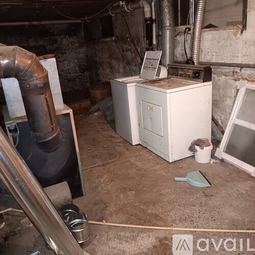 A dirty room with a washing machine and a dryer.