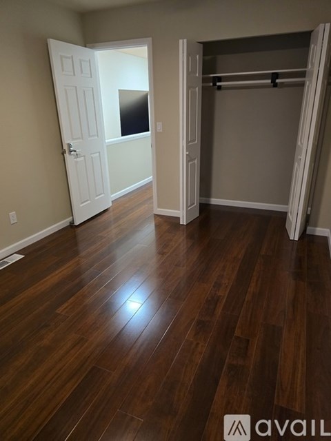 A room with a wooden floor and a white door.
