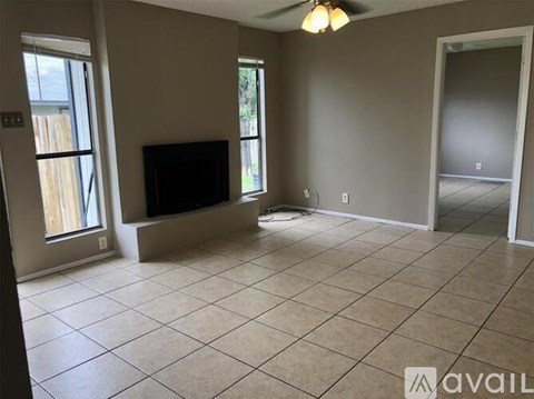 A living room with a television and a ceiling fan.