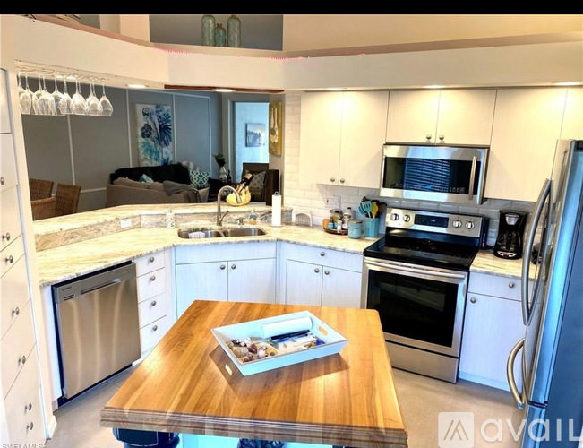 A modern kitchen with a wooden table in the middle.