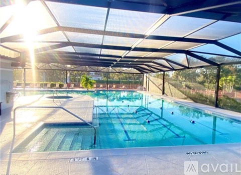 A large indoor swimming pool with sunlight streaming in through the ceiling.