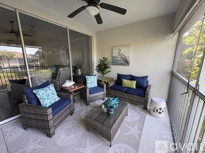 A patio with a sofa, chairs, and a coffee table.