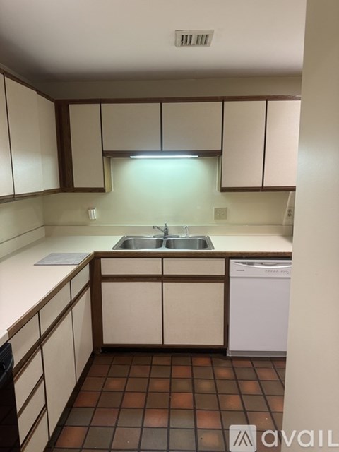 A kitchen with brown cabinets and a white counter.