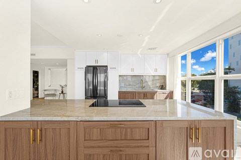 A kitchen with wooden cabinets and a marble countertop.