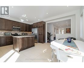 A kitchen with brown cabinets and a white table.