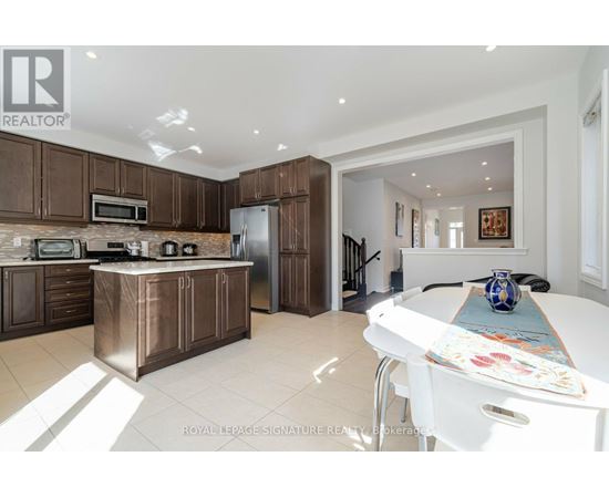 A kitchen with brown cabinets and a white table.