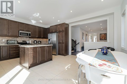 A kitchen with brown cabinets and a white table.