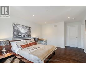 A bedroom with a large bed and a painting on the wall.