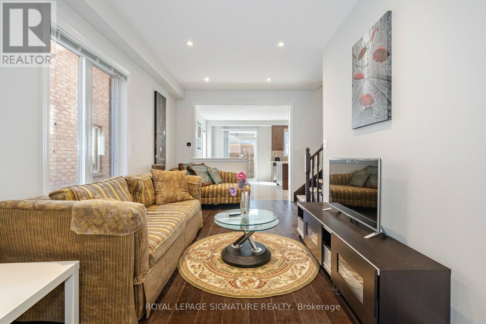 A living room with a brown couch and a glass coffee table.