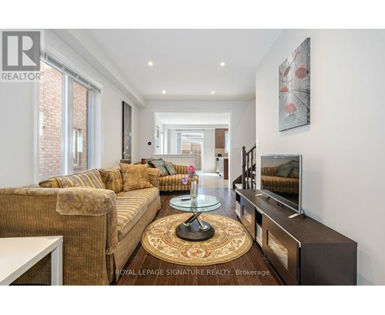 A living room with a brown couch and a glass coffee table.