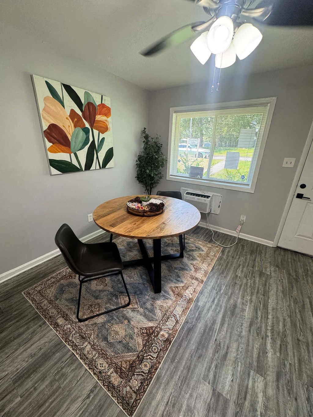 A dining room with a round wooden table and two chairs.