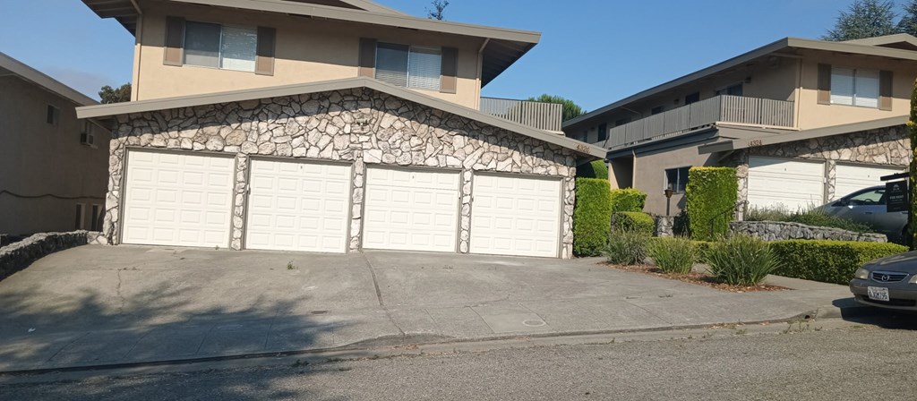 A house with a stone wall and a white garage door.
