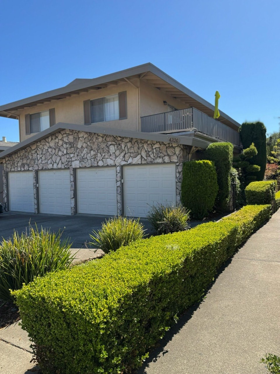 A house with a stone wall and a garage door.