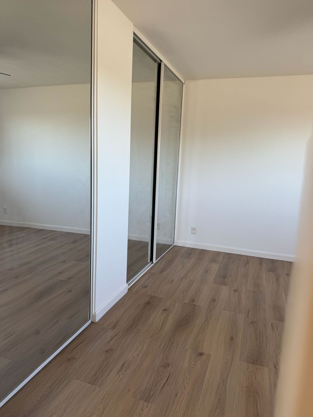 A room with a sliding door and wood flooring.