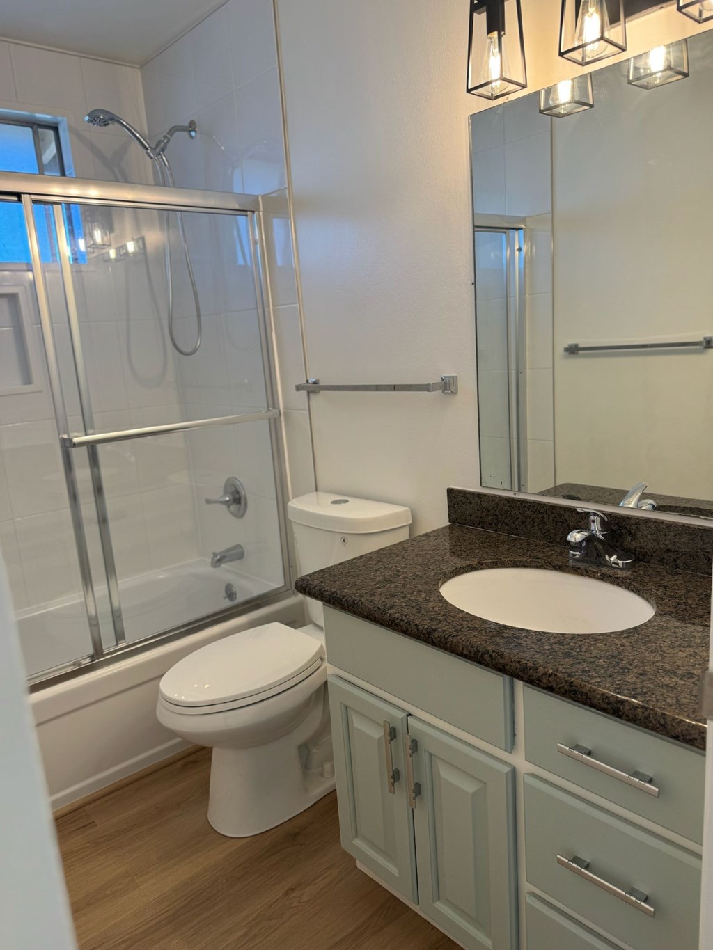 A bathroom with a sink, toilet, and shower.