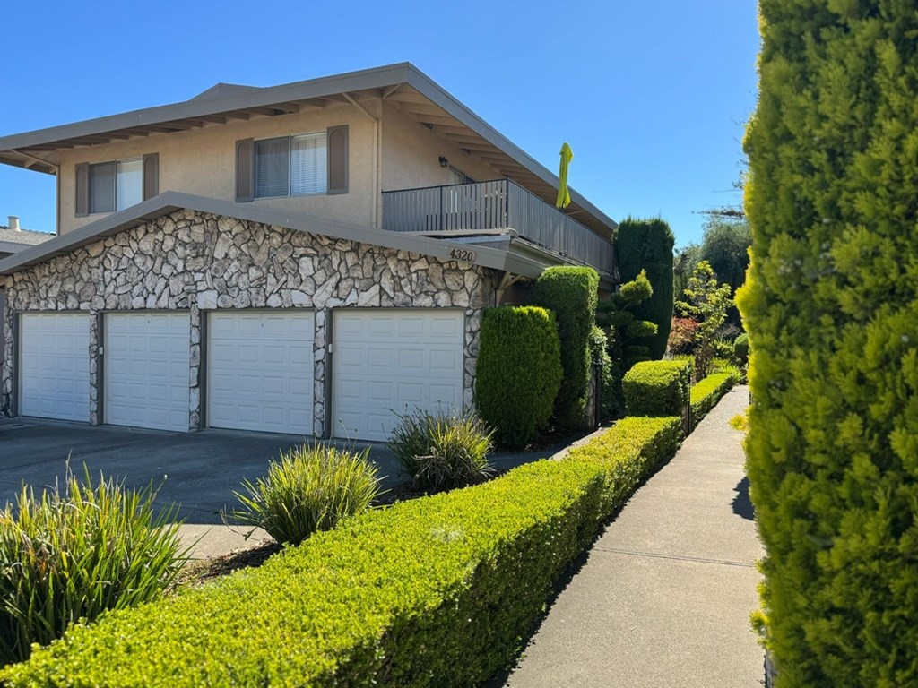 A house with a stone wall and a garage door.