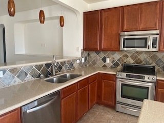 A kitchen with brown cabinets and a tiled backsplash.