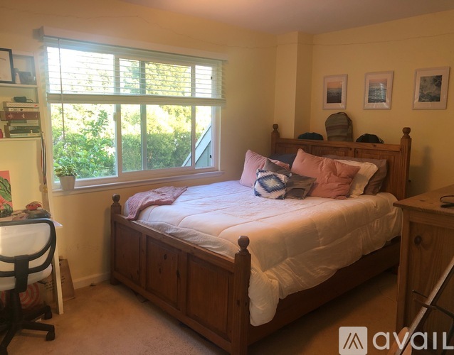 A bedroom with a bed, desk, and chair.