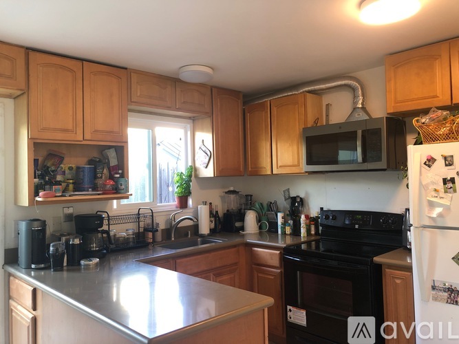 A kitchen with wooden cabinets and a black stove top oven.