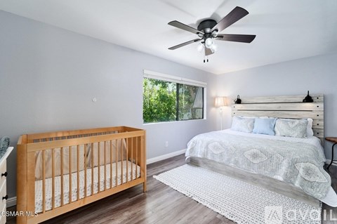 A baby's room with a crib and a bed.