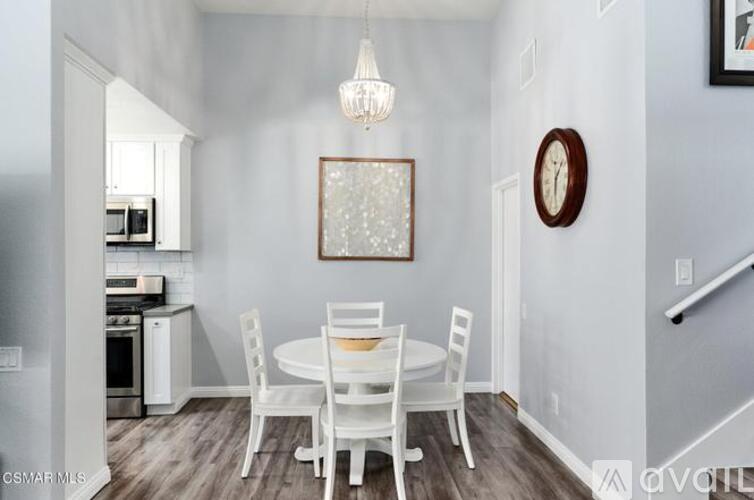 A dining room with a white table and chairs.