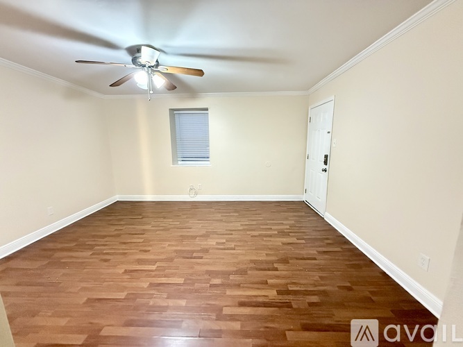 A room with wooden flooring and a ceiling fan.