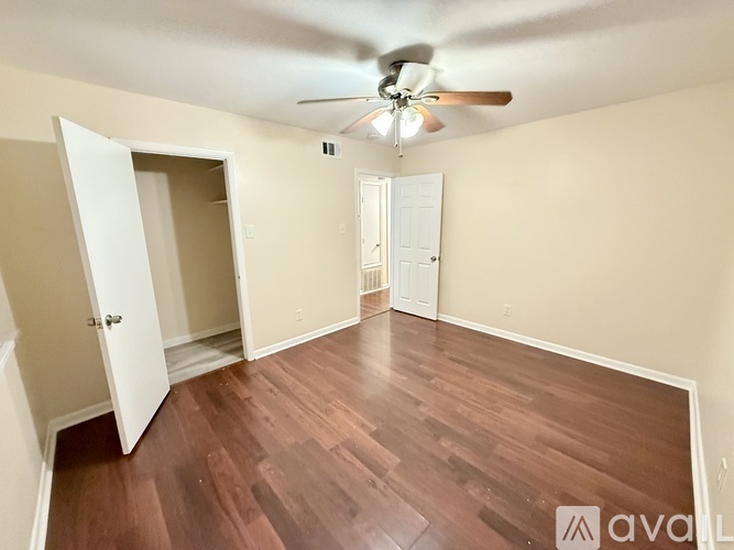 A room with wood flooring and a ceiling fan.