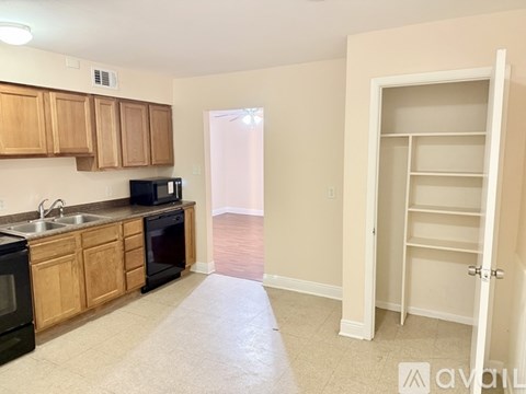 A kitchen with wooden cabinets and black appliances.