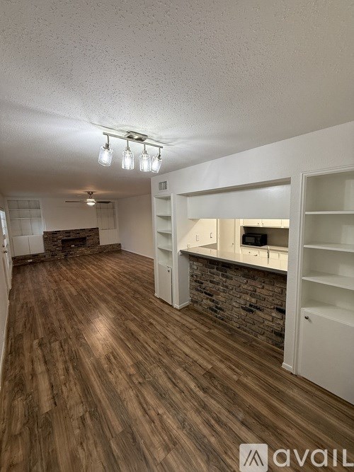 A room with wooden floors and a brick wall.
