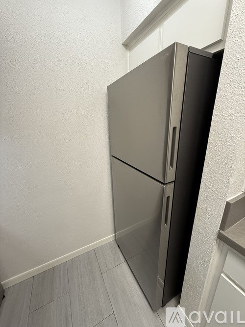 A grey double door fridge in a kitchen.
