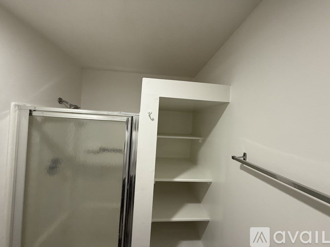 A white closet with a mirror and shelves.