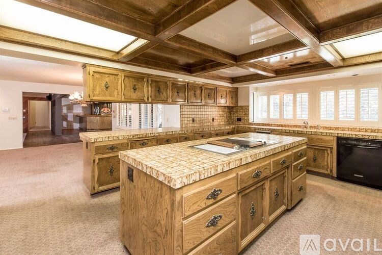 A kitchen with wooden cabinets and a marble countertop.