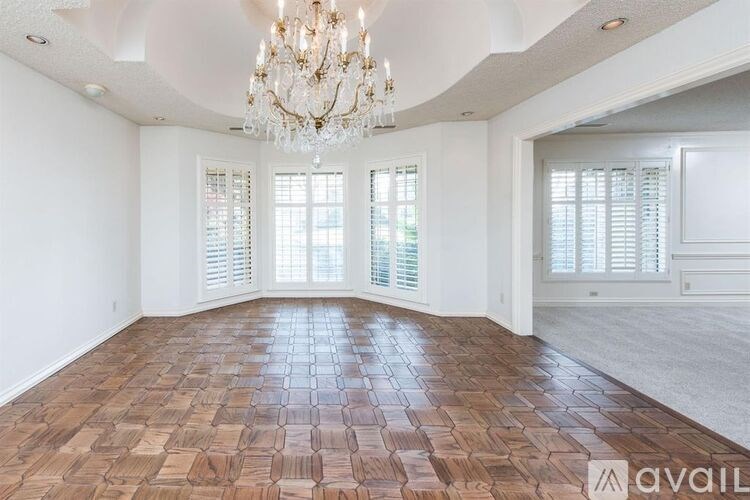 A room with a chandelier and wooden flooring is available for rent.