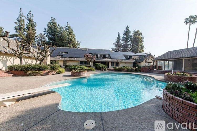 A pool surrounded by a brick wall and trees.