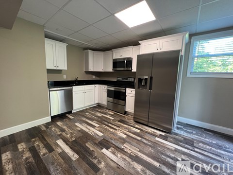 A kitchen with wood flooring and stainless steel appliances.