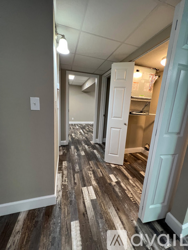 A hallway with a light switch on the wall and a door on the right.