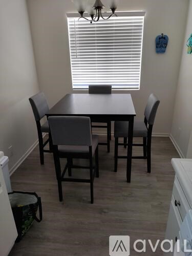 A dining room with a table and chairs.